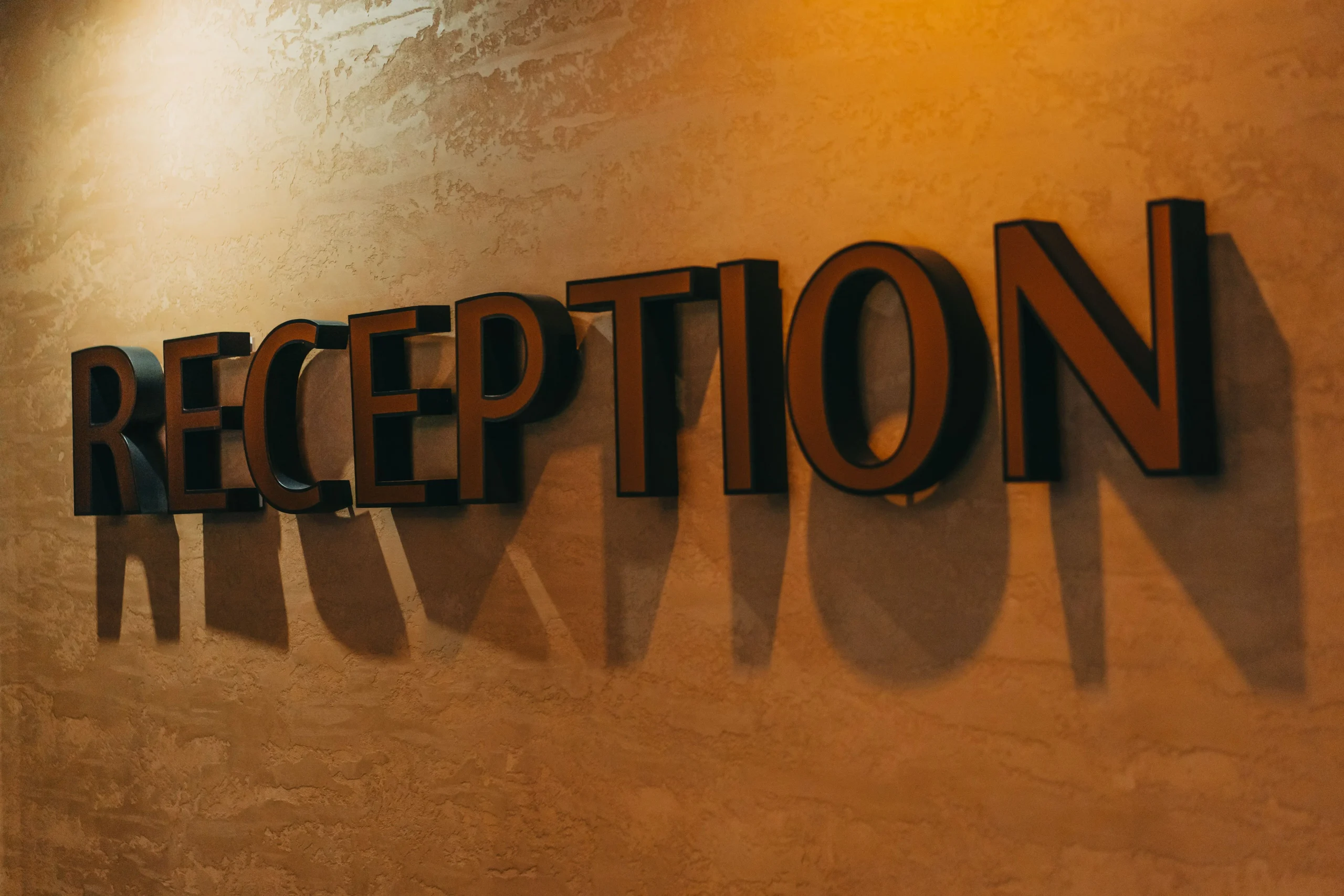 Modern office reception with dimensional logo letters and branded feature wall